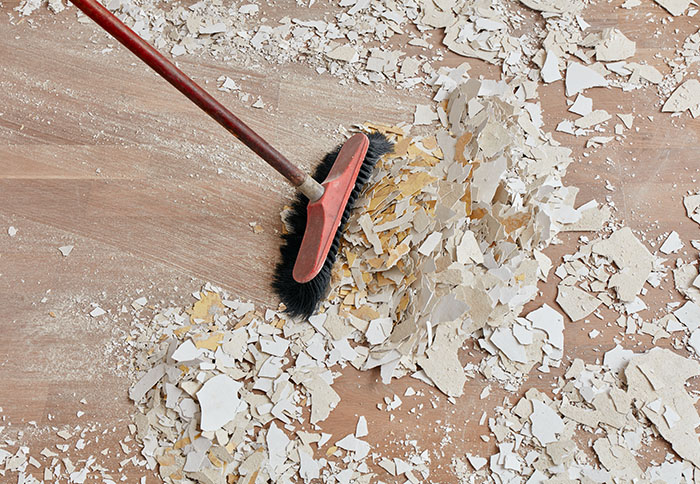 Person sweeping the floor after renovation